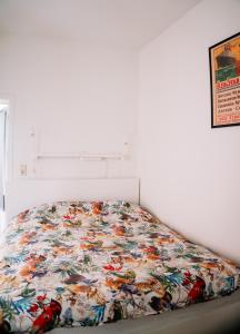 a bed with a colorful comforter on it at Appartement vlakbij Antwerpen centrum! in Antwerp