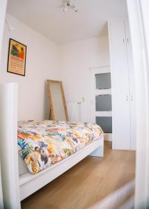 a bedroom with a bed with a colorful quilt at Appartement vlakbij Antwerpen centrum! in Antwerp