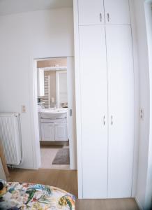 a white bathroom with a sink and a mirror at Appartement vlakbij Antwerpen centrum! in Antwerp