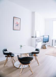 a dining room with a white table and chairs at Appartement vlakbij Antwerpen centrum! in Antwerp
