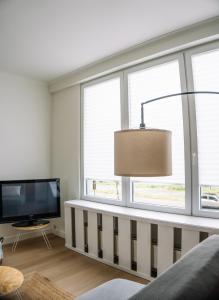 a living room with a tv and a large window at Appartement vlakbij Antwerpen centrum! in Antwerp