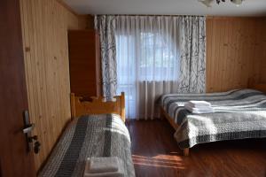 ブコビナ・タトシャンスカにあるBukowiański Dworekのベッドルーム1室(ベッド2台、窓付)