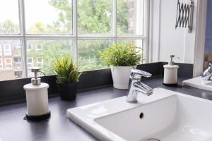 a bathroom counter with a sink and a window at Prime Backpackers Angel in London