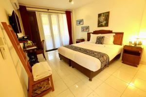 una camera con un letto e una televisione di Manzelejepun Luxury Villa & Pavilion a Sanur