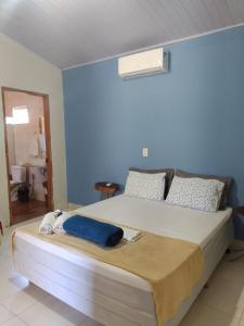 um quarto com uma cama grande e uma parede azul em Pouso Divino dos Pireneus em Pirenópolis