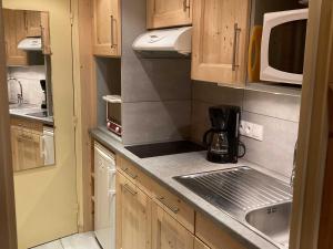 a small kitchen with a sink and a microwave at Studio Le Grand-Bornand, 1 pièce, 3 personnes - FR-1-467-116 in Le Grand-Bornand