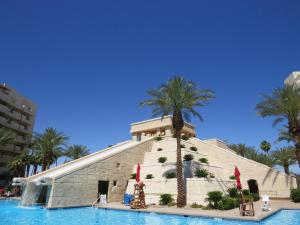 un bâtiment avec un palmier à côté d'une piscine dans l'établissement Enticing Huge Unit at Cancun Resort Strip Las Vegas, à Las Vegas