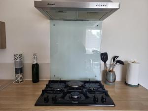 a kitchen with a stove top oven in a kitchen at Maison au calme Avignon - Clim - Wi-Fi in Avignon