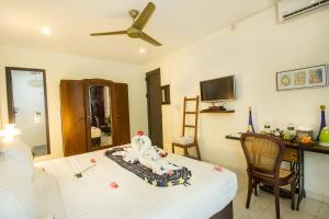 Una habitación con una cama y una mesa con una estatua. en Manzelejepun Luxury Villa & Pavilion en Sanur