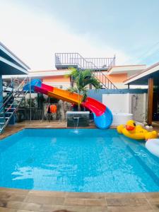 a pool with a water slide in a house at เจ๋งพูลวิลล่า ชะอำ in Cha Am