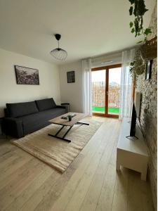 a living room with a couch and a table at L'envolée - 15' de Paris & 10' du Stade de France in Saint-Denis