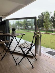 une table en bois et une chaise sur une terrasse couverte dans l'établissement Timur bay groundfloor pool & seaview, à Kuantan
