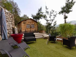 einen Hinterhof mit Stühlen und einem Blockhaus in der Unterkunft Holiday Home in Le Cheylard with Fireplace in Le Cheylard