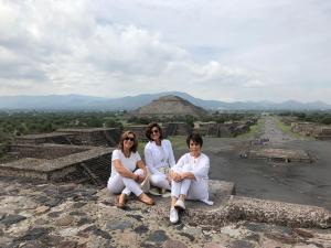 três mulheres sentadas em cima de uma pirâmide em Casaluna em Malinalco