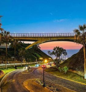 een brug over een weg waar auto's onder rijden bij Miraflores centro in Lima