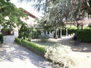 un jardín frente a un edificio con árboles y arbustos en Anema Home, en Serino