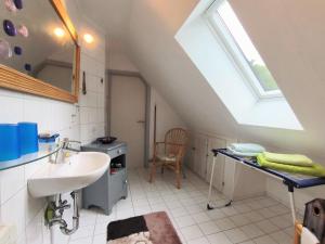 a white bathroom with a sink and a window at Ferienzimmer Neuhaus in Sieverstedt