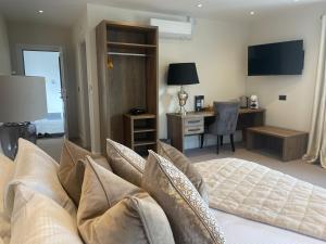 a bedroom with a bed with pillows and a desk at The Green Inn in Goole