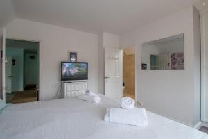 um quarto branco com 2 toalhas numa cama em Elegant and spacious private room with ensuite em Luton