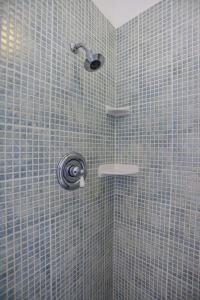 a bathroom with a shower with blue tiles at At Home in the Tropics in Charlotte Amalie