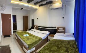 2 camas en una habitación con cortinas azules en Dakshinakasi Guest House, en Thirunelli