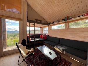 a living room with a couch and a table at Veslestølen - Ålhytte with amazing view, 1000 meter in Ål