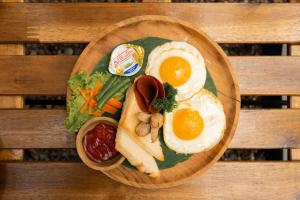 德哥拉朗的住宿－Bobocabin Ubud, Bali，鸡蛋、面包和蔬菜等食物