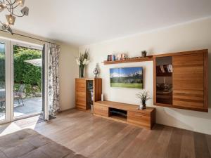 uma sala de estar com uma televisão na parede em Alpensuiten em Ellmau