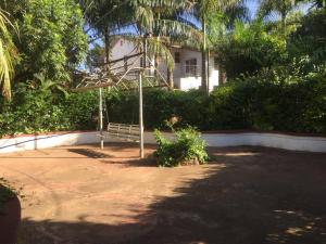 een park met een bankje voor een huis bij Pacho studio Apartment in Kisumu