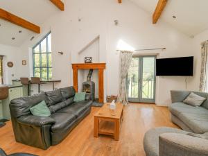 a living room with a couch and a fireplace at The Coach House at Plas Dolguog in Machynlleth