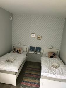 two beds in a room with white sheets at Jädra Gårdshotel in Enköping