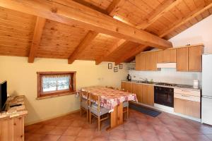 a kitchen with a table and a kitchen with wooden ceilings at Baita Campacc Marco in Livigno