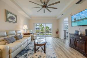 a living room with a couch and a flat screen tv at Closest to the Pool! - Updated, Bright & Cheery - Condo Serenity Cove - Roelens Vacations in Cape Coral