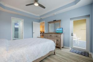 a bedroom with a bed and a flat screen tv at Closest to the Pool! - Updated, Bright & Cheery - Condo Serenity Cove - Roelens Vacations in Cape Coral