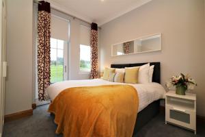 a bedroom with a large bed and a large window at Greenlees Clubhouse 3 Bed in Cambuslang