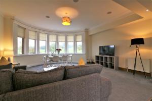 a living room with a couch and a table at Greenlees Clubhouse 3 Bed in Cambuslang