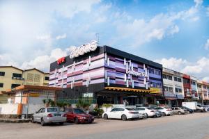 a building with cars parked in a parking lot at OYO 902 Rooms Boutique Hotel in Johor Bahru