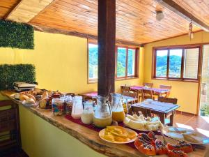 a table with a bunch of food on it at Pousada Cantinho da Montanha 2 in Visconde De Maua
