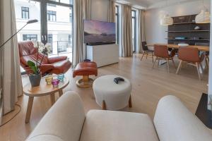 uma sala de estar com um sofá, cadeiras e uma mesa em Villa Claire Duenenloft em Ostseebad Sellin