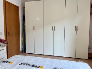 a bedroom with white cabinets and a bed at Oliveri nuovo appartamento 5 posti letto più posto auto privato in Oliveri