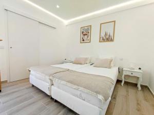 a white bedroom with a large bed and a table at Lovely Terrace Studio Baixa Faro in Faro