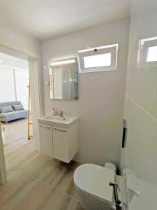 a white bathroom with a toilet and a sink at Lovely Terrace Studio Baixa Faro in Faro