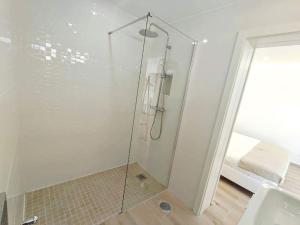 a shower with a glass door in a bathroom at Lovely Terrace Studio Baixa Faro in Faro