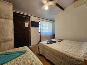 1 dormitorio con 2 camas y ventilador de techo en Suíte Água Branca Residencial Exclusive, en Ilhabela