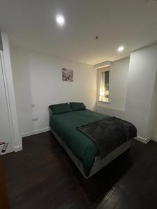 a bedroom with a green bed and a window at Amazing 1 Bedroom Flat in Essex TH104 in Basildon