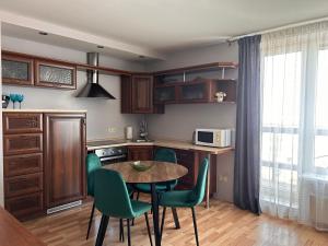 cocina con mesa y sillas verdes en Baltijos 12b Apartamentai, en Klaipėda
