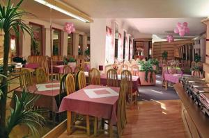 un restaurante con mesas, sillas y adornos de color rosa en Hotel Maggi, en Rogoźno