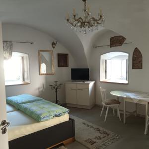 a bedroom with a bed and a table and a chandelier at Im Gewölbe der Alten Druckerei in Viechtach