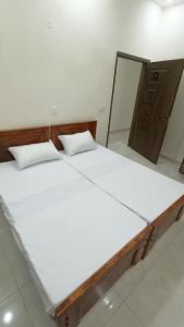 a large white bed in a room with a mirror at Continental Boys Hostel R-2 Johar Town in Lahore