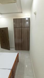 an empty room with wooden cabinets and a white floor at Continental Boys Hostel R-2 Johar Town in Lahore